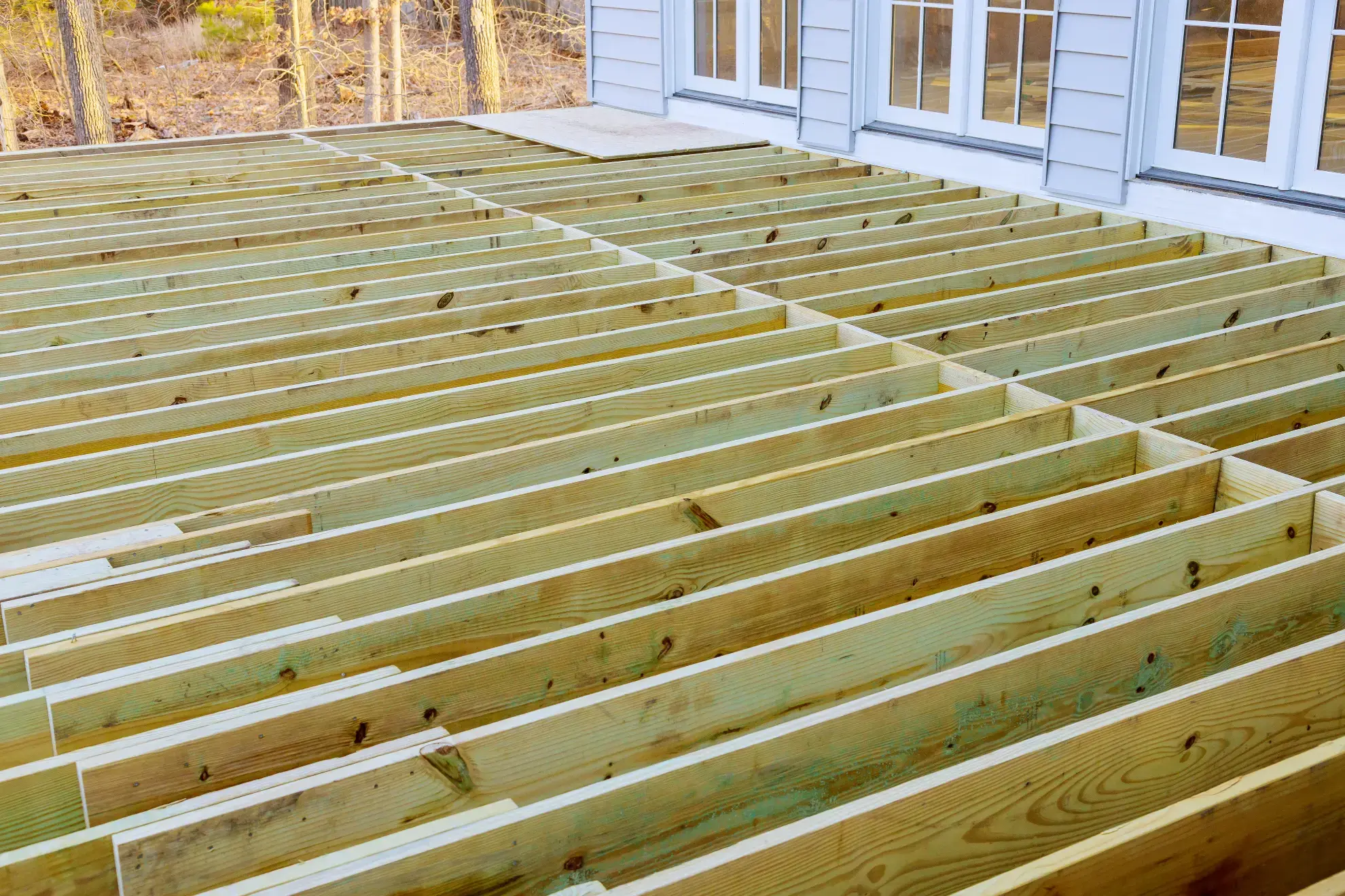 Deck builder in New Hampshire framing a composite deck