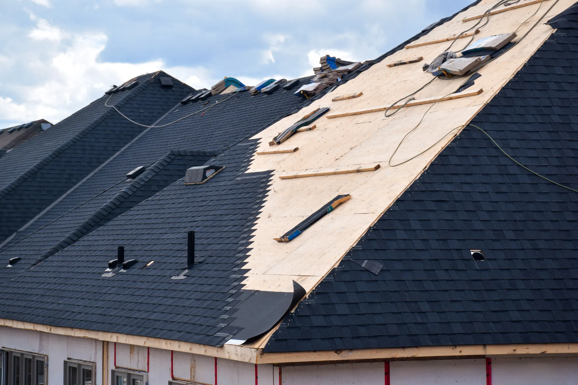 Roofing crew installing architectural shingles on a residential home in New Hampshire